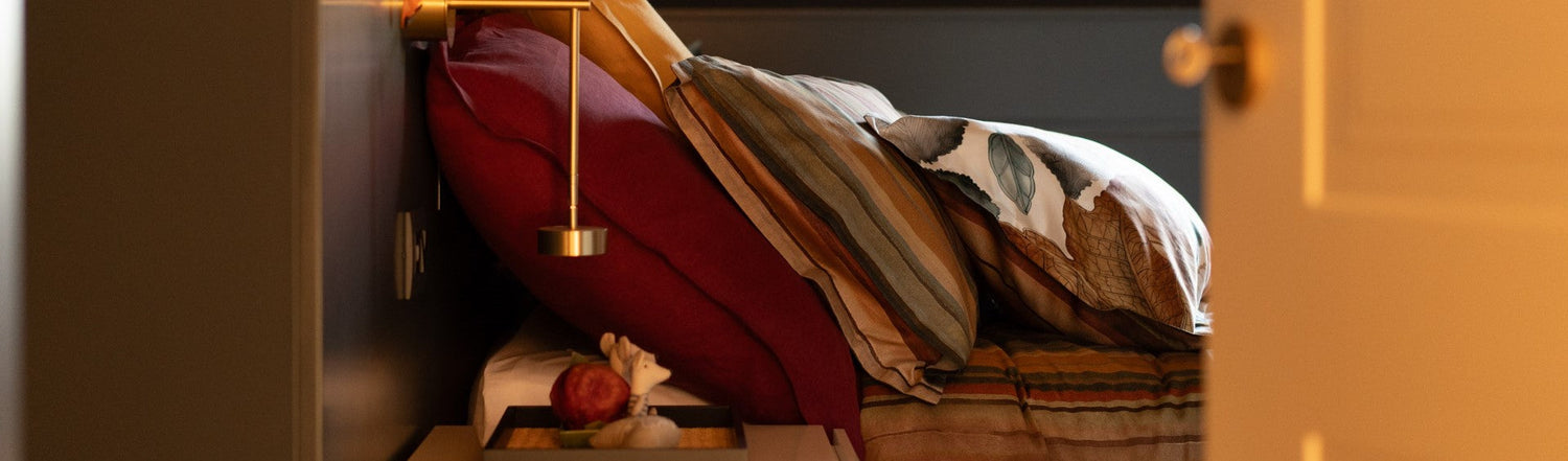 Cuscini decorativi accostati su un letto coordinato